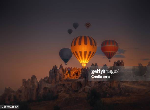 hot air balloons flying over rock formations in cappadocia, goreme, turkey - cappadocia hot air balloon stock pictures, royalty-free photos & images