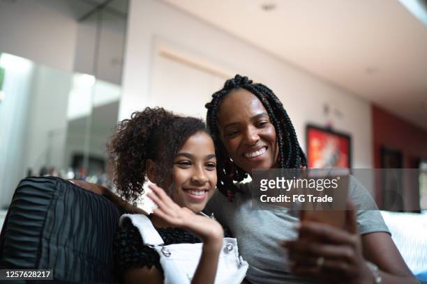 moeder en dochter die een videovraag thuis doen - very young webcam girls stockfoto's en -beelden