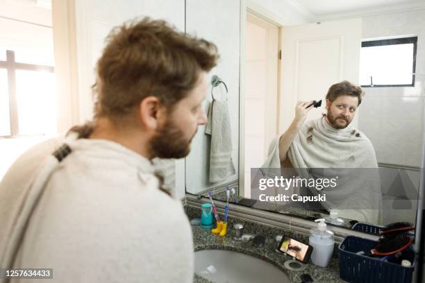 man getting a self haircut at home. - lockdown haircut stock pictures, royalty-free photos & images