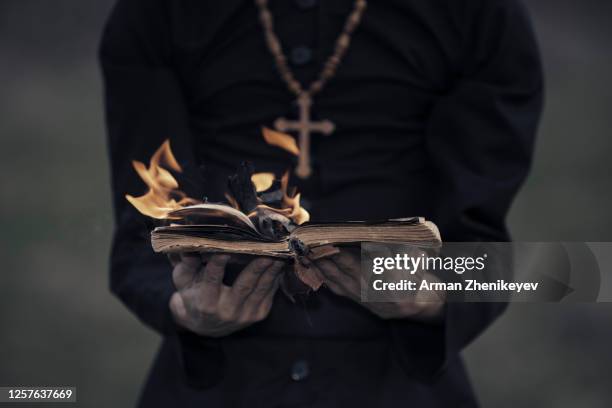 religious man with burn bible - barrage diablo photos et images de collection