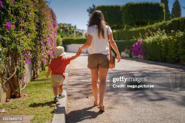 mother and son walking down the street - woman walks down street stock pictures, royalty-free photos & images