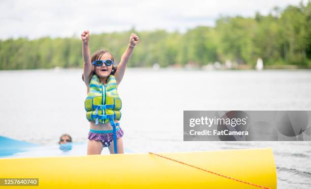little girl plays in water - child life jacket stock pictures, royalty-free photos & images