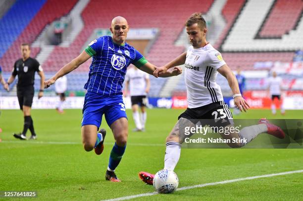 Joe Bryan of Fulham is challenged by Kal Naismith of Wigan Athletic during the Sky Bet Championship match between Wigan Athletic and Fulham at DW...