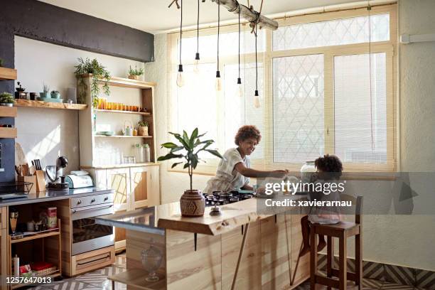 preschool age daughter enjoying breakfast with mother - kitchen island stock pictures, royalty-free photos & images