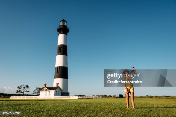 meisje dat een selfie op de zomerreis neemt - north carolina lighthouse stockfoto's en -beelden