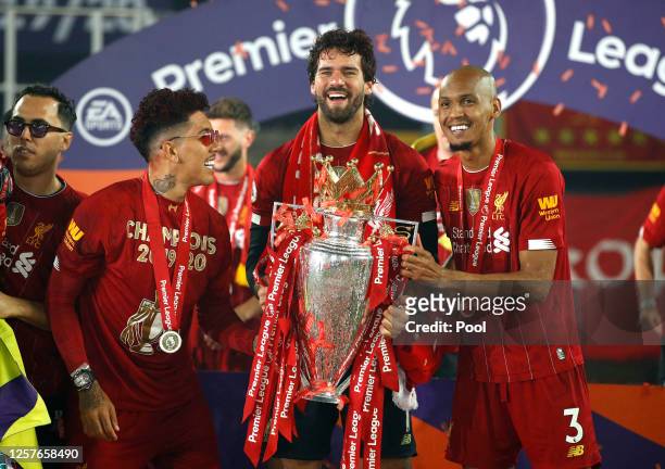 Roberto Firmino, Alisson Becker and Fabinho of Liverpool celebrate with The Premier League trophy following the Premier League match between...