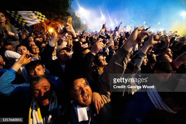 Leeds United supporters celebrate as the Leeds United players lift the Sky Bet Championship trophy outside of the stadium in front of their fans...
