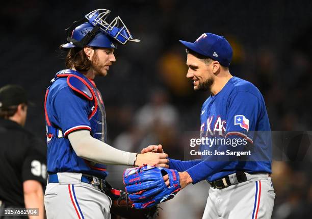 Pitcher Nathan Eovaldi of the Texas Rangers celebrates with Jonah Heim after throwing a 6-1 complete game against the Pittsburgh Pirates at PNC Park...