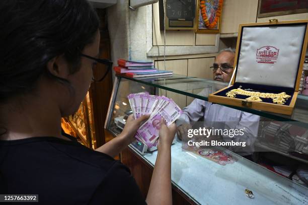 Customer counts 2,000 rupee banknotes at a jewelry store in New Delhi, India, on Tuesday, May 23, 2023. India withdrawing its highest value currency...