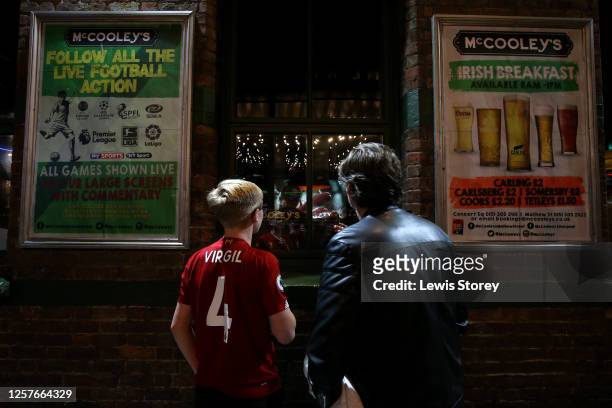 Liverpool fans watch the trophy lift from outside a pub following the Premier League match between Liverpool FC and Chelsea FC at Anfield on July 22,...