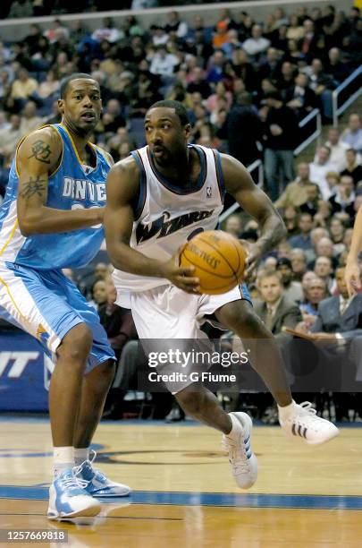 Gilbert Arenas of the Washington Wizards handles the ball against Marcus Camby of the Denver Nuggets on November 22, 2005 at the MCI Center in...