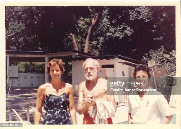 Author Ernest Hemingway poses for a photo with Anne Rynearson Cummins and Marjie Rynearson at the Rynearson family home in June 1961 in Rochester,...