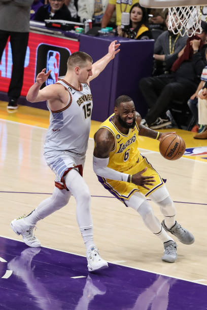 Los Angeles Lakers forward LeBron James drives past Denver Nuggets center Nikola Jokic during the Denver Nuggets versus the Los Angeles Lakers in...
