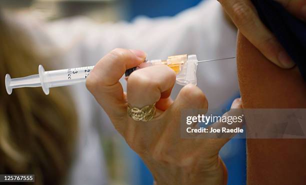 University of Miami pediatrician, Judith L. Schaechter, M.D., gives an HPV vaccination to a 13-year-old girl in her office at the Miller School of...