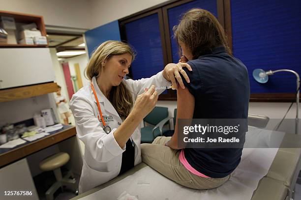 University of Miami pediatrician Judith L. Schaechter, M.D. Gives an HPV vaccination to a 13-year-old girl in her office at the Miller School of...