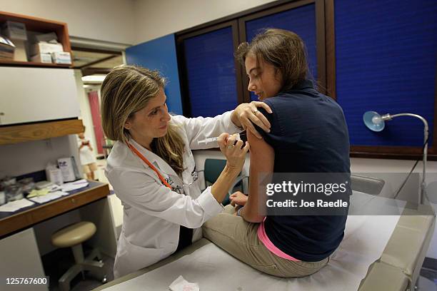 University of Miami pediatrician Judith L. Schaechter, M.D. Gives an HPV vaccination to a 13-year-old girl in her office at the Miller School of...