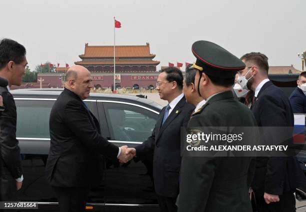 Russian Prime Minister Mikhail Mishustin shakes hands after talks with Chinese officials in Beijing on May 24, 2023. / "The erroneous mention[s]...