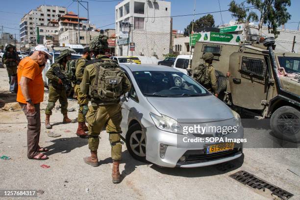 Israeli soldiers and paramedics inspect an Israeli settler's car after it was pelted with stones, in the town of Hawara, south of Nablus, in the...