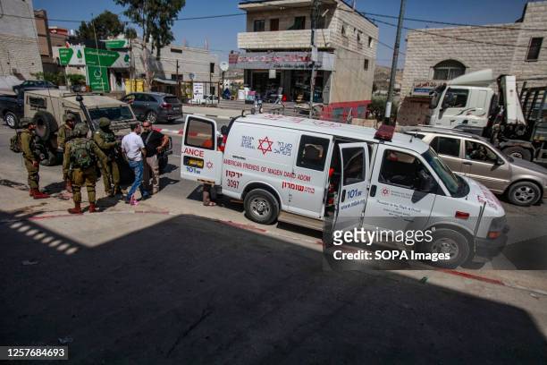 Israeli soldiers and medics near the site where stones were thrown at an Israeli settler's car, in the town of Hawara, south of Nablus, in the...