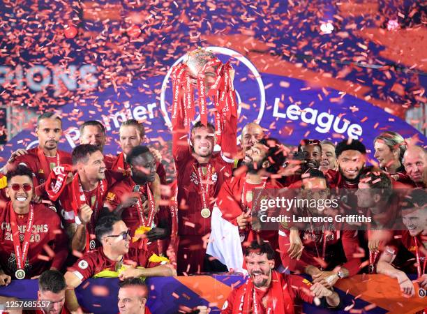 Jordan Henderson of Liverpool holds the Premier League Trophy aloft along side Mohamed Salah as they celebrate winning the League during the...