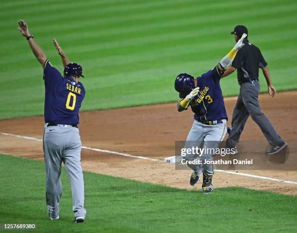Orlando Arcia of the Milwaukee Brewers has a "social distance" celebration with third base coach Ed Sedar after hitting a solo home run in the 9th...