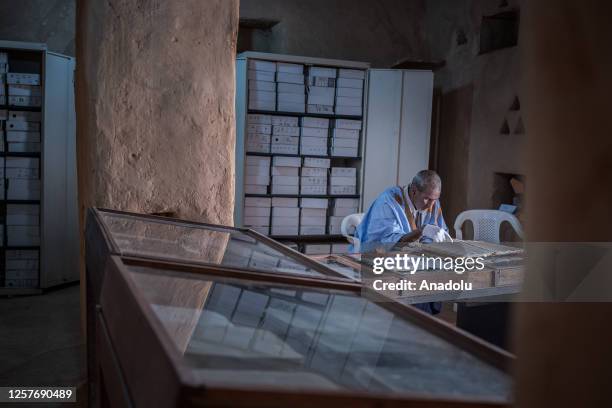 Abdullah Habott, the book preserver, observes ancient handwriting manuscripts in Chinguetti, Mauritania on May 10, 2023. The towns Chinguetti, that...