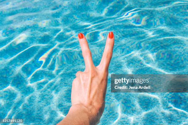 peace sign summer swimming pool tourist - victory sign stock-fotos und bilder