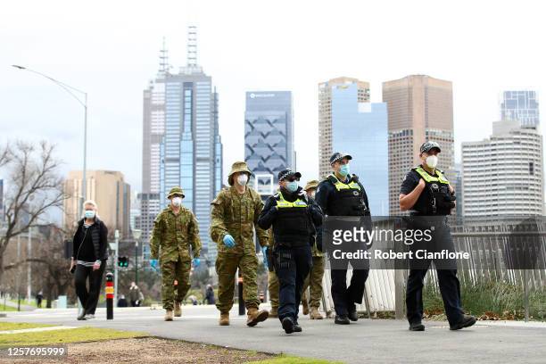 Police and the Australian military patrol the banks of the Yarra River on July 23, 2020 in Melbourne, Australia. Face masks or face coverings are now...