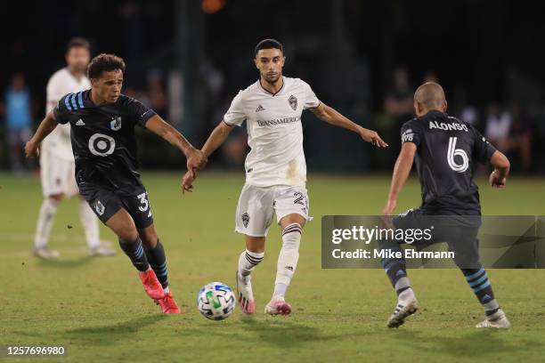 Younes Namli of Colorado Rapids fights for the ball with Hassani Dotson and Osvaldo Alonso of Minnesota United during a match between Colorado Rapids...