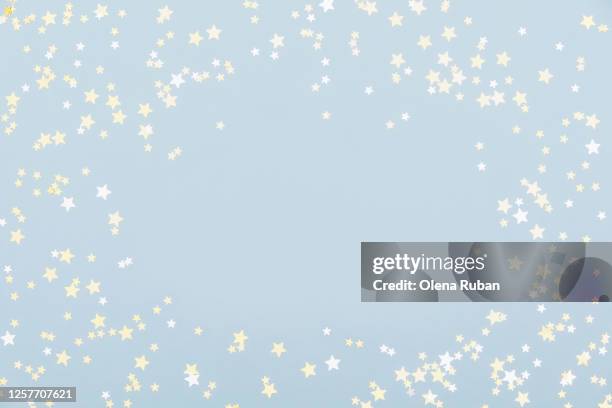 bright golden stars on light blue background - confetti light blue background stock pictures, royalty-free photos & images