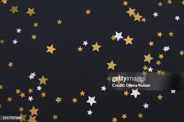 bright golden stars on black background - star background stock-fotos und bilder