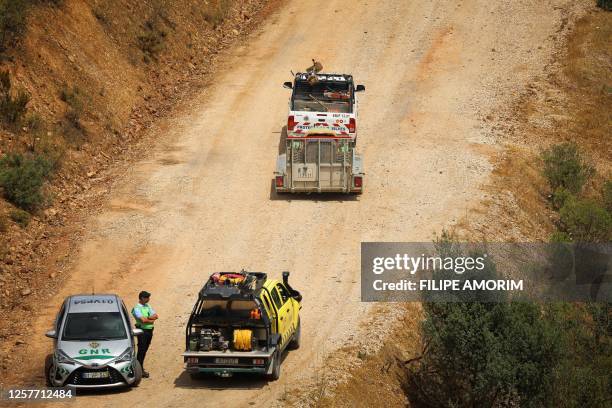 Portuguese National Republican Guard stands as a machine is carried in the Arade dam area, in Silves, on 24 May, 2023 on the second day of a new...