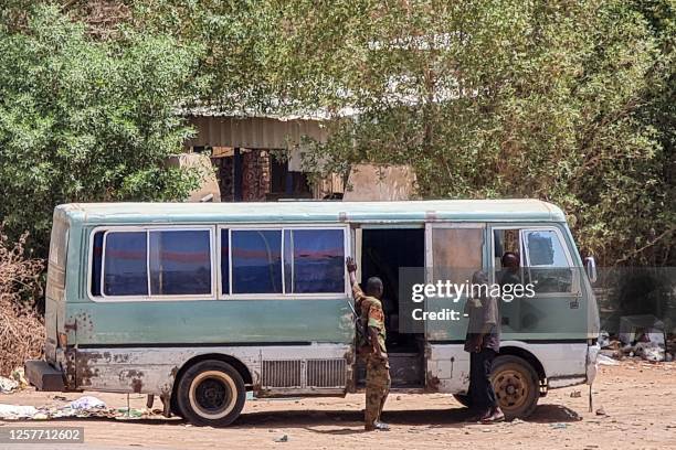 Sudanese army soldiers stop a minibus for inspection at a checkpoint in southern Khartoum on May 24, 2023. Sporadic artillery fire still echoed in...