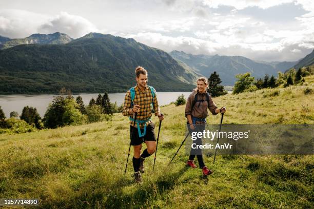 young couple hiking together outdoors - hiking pole stock pictures, royalty-free photos & images