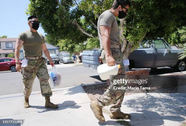 Army National Guard specialists John Cho and John Esparza deliver food to a senior citizen in hard-hit Imperial County amid the COVID-19 pandemic on...