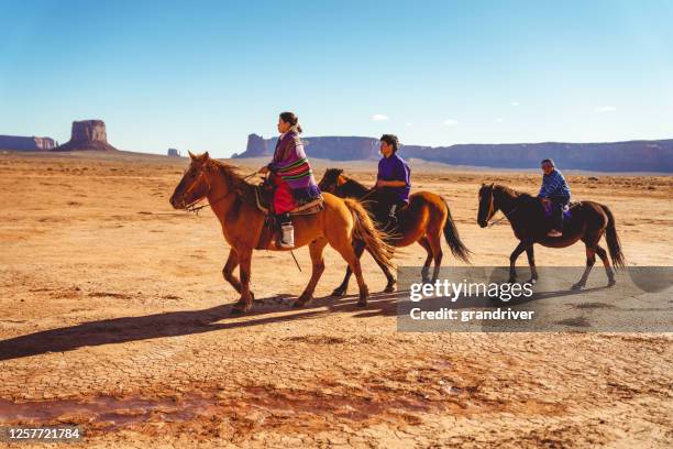 drie jonge navajo tiener siblings die paarden in de woestijn van de vallei van het monument van olijato van noordelijk arizona dichtbij de grens van utah op een zonnige dag berijden - horse blanket stockfoto's en -beelden