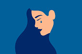 Sad young girl is crying on a blue background.