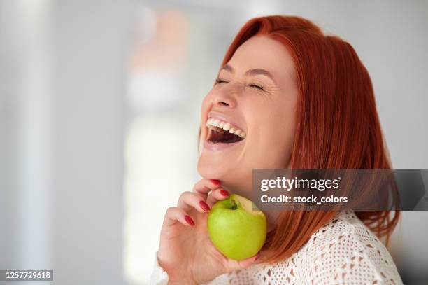 rire et s’amuser pendant un mode de vie sain - pomme croquée photos et images de collection