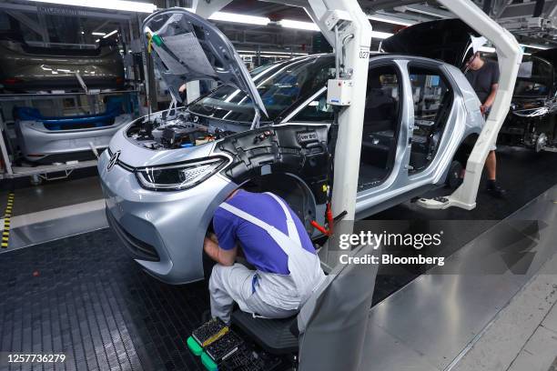 Employees fit a bumper to a Volkswagen AG VW ID.3 car on the assembly line at the Volkswagen Sachsen GmbH plant in Zwickau, Germany, on Wednesday,...