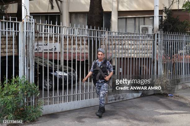 An officer stands guard outside the Justice Palace where Lebanese central bank chief Riad Salameh appeared for questioning, in Beirut on May 24,...