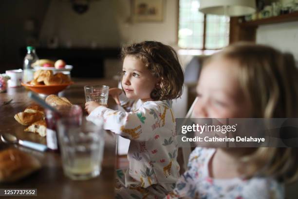 2 little girls having their breakfast - cozy kitchen stockfoto's en -beelden