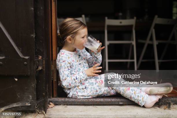 a 5 year old girl drinking a glass of milk - kind im grundschulalter stock-fotos und bilder