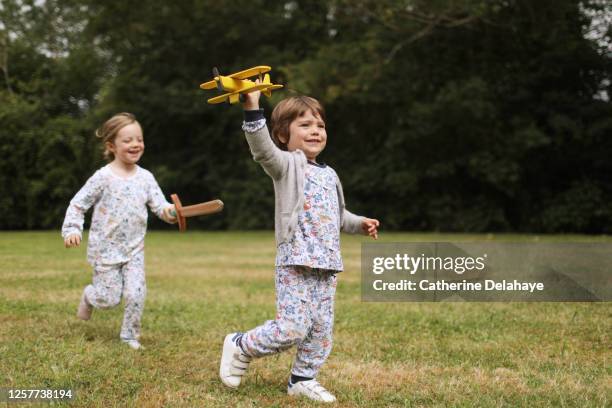 a sister and a brother playing in the garden - pigiama foto e immagini stock