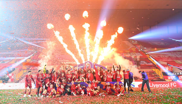 The Liverpool Team celebrate on the pitch after winning the Premier League Title during the presentation ceremony of the Premier League match between...