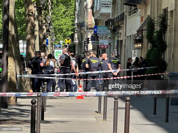 Police and firefighting personnel gather at the scene of a shooting in Paris on May 24 after gunmen on two scooters reportedly opened fire and killed...