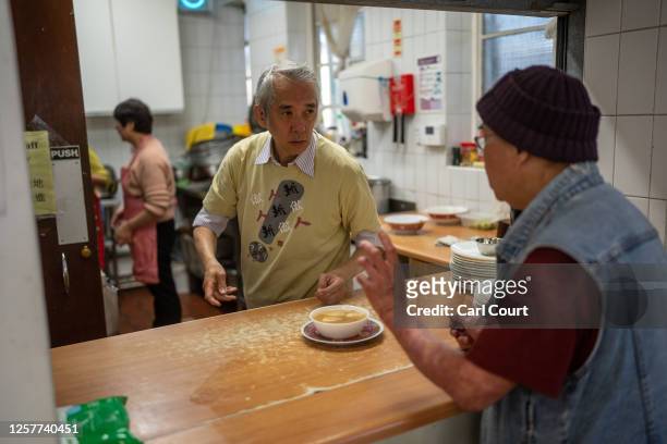 Volunteers serve lunch at a Chinese community centre that assists and supports people from east and southeast Asia, in Hackney on May 24, 2023 in...