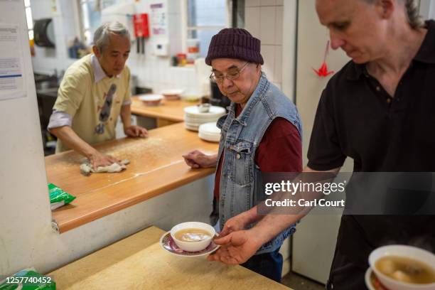 Volunteers serve lunch at a Chinese community centre that assists and supports people from east and southeast Asia, in Hackney on May 24, 2023 in...