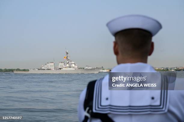 Sailor watches as the USS Cole sails through New York Harbor during Fleet Week on May 24, 2023.