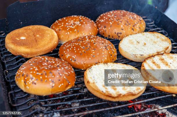 burger buns lightly toasted on grill - metal grate stock pictures, royalty-free photos & images