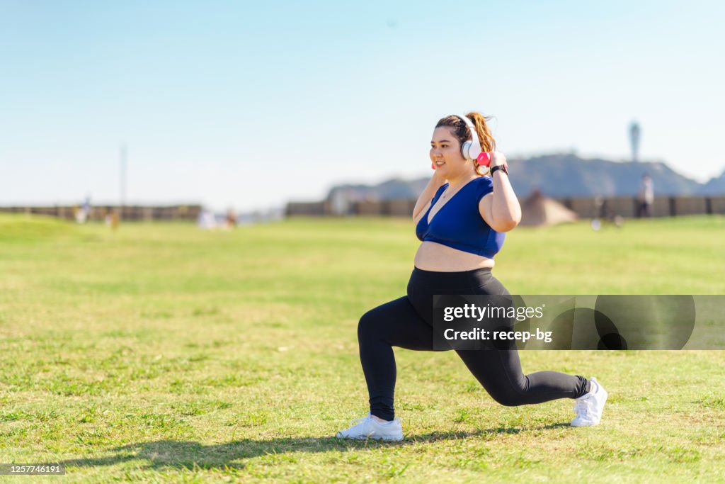 Jovem atleta fazendo treinamentos musculares com halteres em parque público